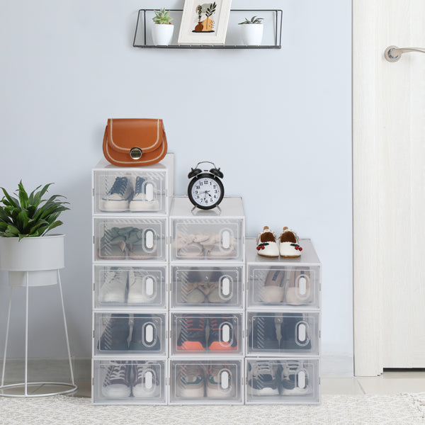 Six drop-front shoe boxes stacked beside a door with sneakers inside