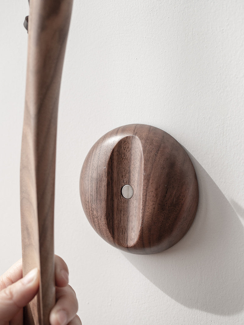 Close-up of the walnut wall disc holding the shoe horn by its magnet