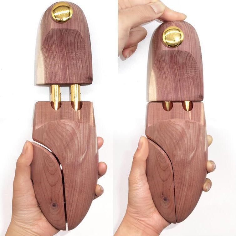 Cedar shoe tree with split toe and brass knob, held in hand