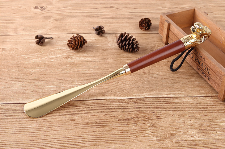 Brown wood Lion Head shoe horn with gold metal blade and cord