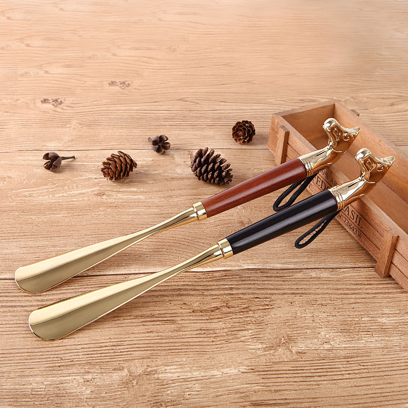 Lion Head shoe horns in light brown and black wood with gold metal blades